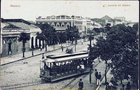 Fotografía antigua de un tranvía eléctrico en una avenida ancha con edificios de dos plantas