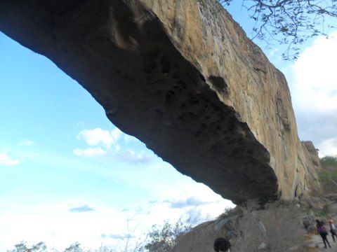 Arco de granito de la Pedra Furada de Venturosa visto desde abajo contra el cielo azul