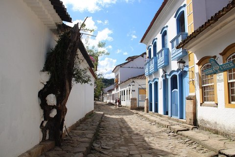 Casas coloniales blancas con puertas azules en una calle empedrada de Paraty