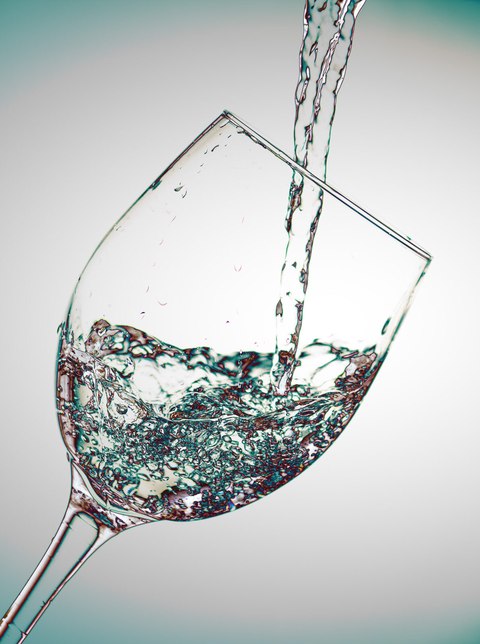 Agua cayendo dentro de un vaso de cristal