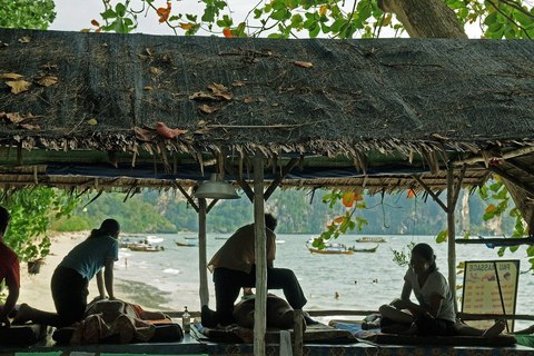 Masajistas trabajando bajo un techado de palma junto al mar